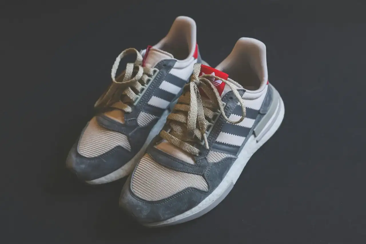 Szare i beżowe buty sportowe Adidas z trzema paskami, idealne na kampusowe wędrówki.
